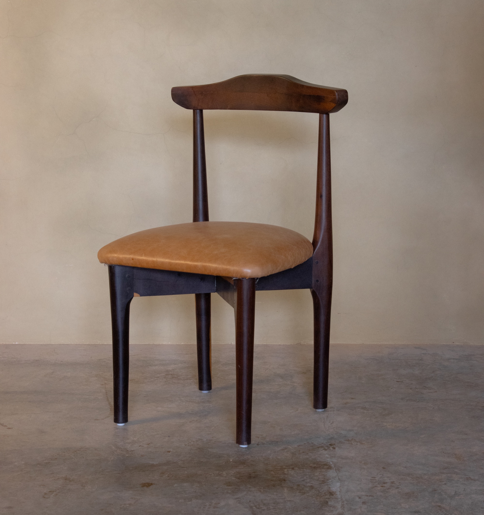 Silla de madera oscura con asiento de piel color miel
