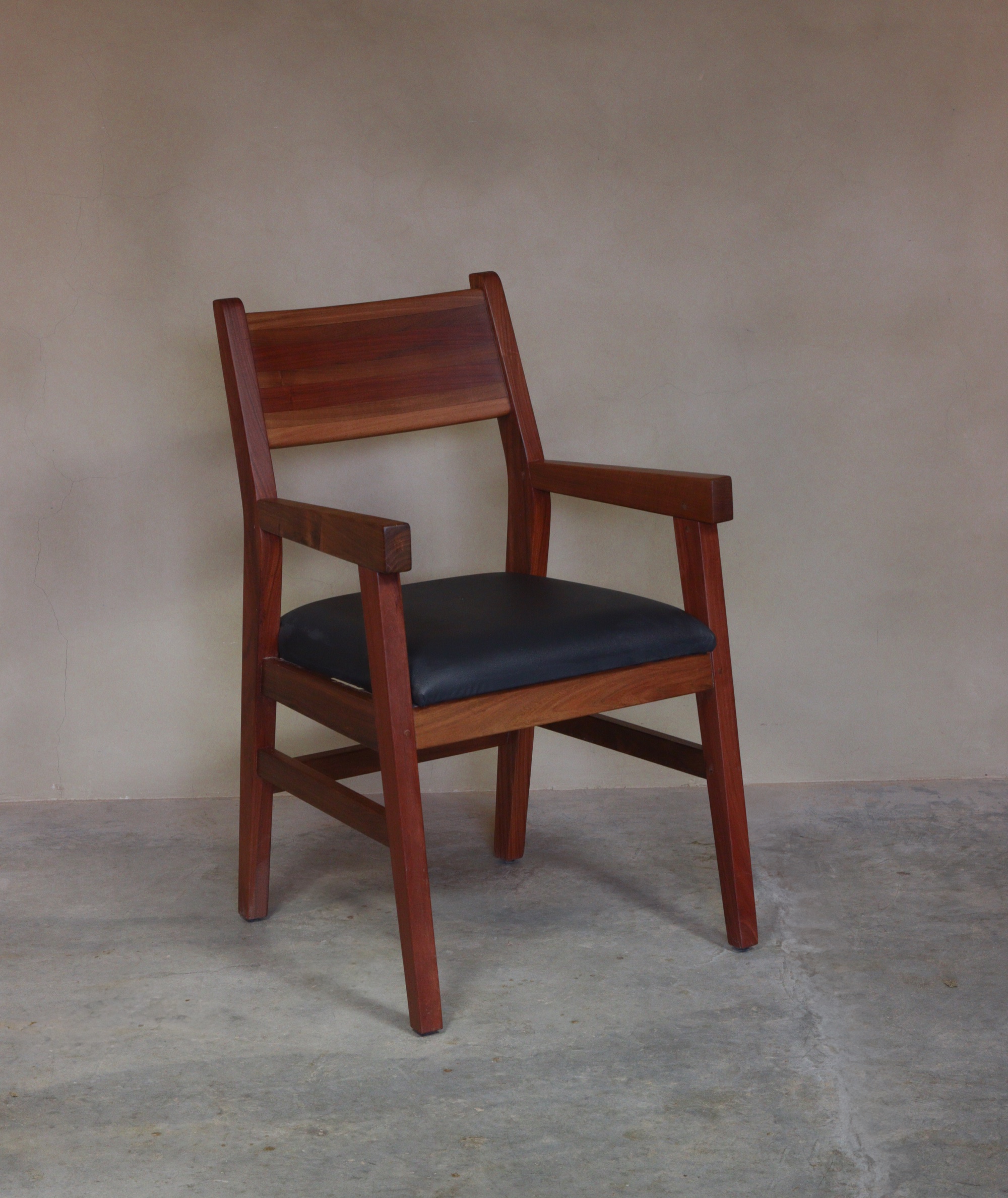 Silla de madera con brazos y asiento tapizado oscuro